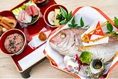 尾頭付きの鯛やお刺身が並ぶお祝いの膳