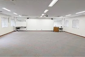 ホワイトボードと演台が設置された、広々とした研修室の内観。