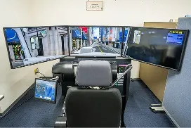 3面モニターとシートが設置されたドライビングシミュレーター。