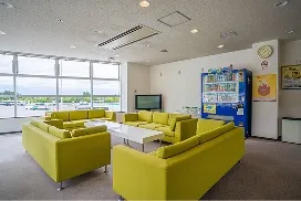黄緑色のソファと自動販売機が置かれた、明るい待合・休憩スペース。