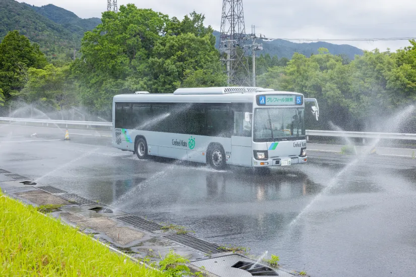散水路でスリップ防止訓練を行う路線バス