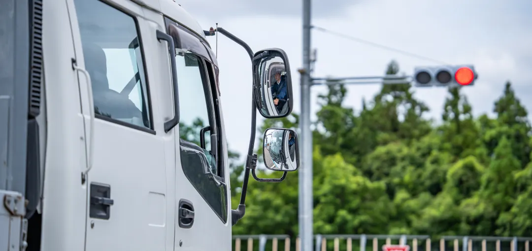 赤信号で停車中の白いトラック。