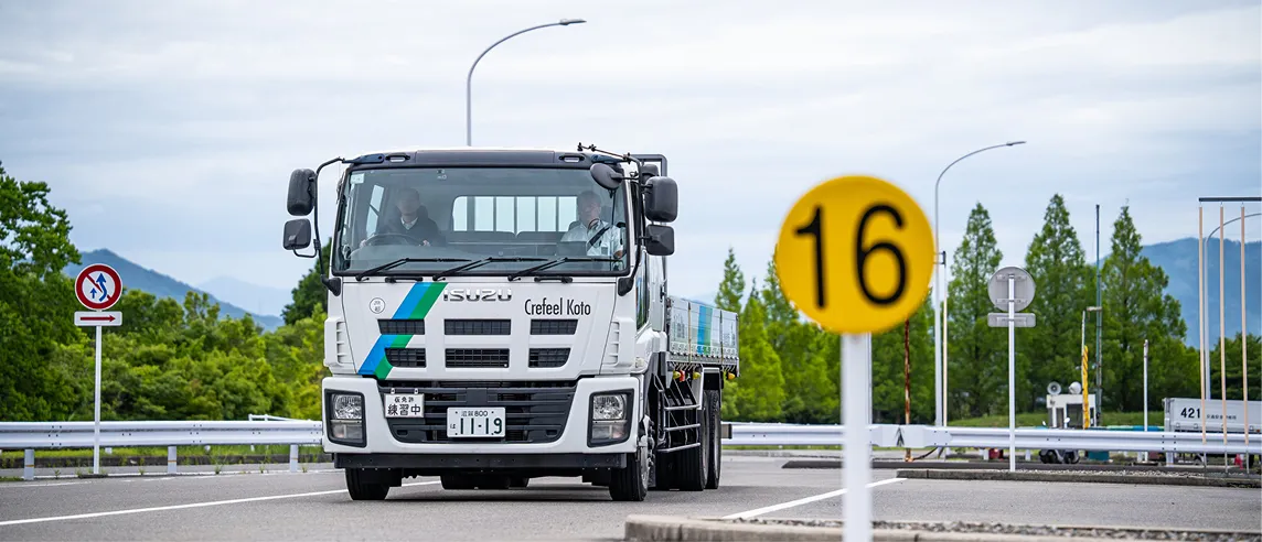 自動車教習所の練習コースを走行する中型教習トラック。