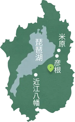 滋賀県を模った地図画像。中央に琵琶湖が薄い青色で描かれ、その東側に米原と彦根の地名があり、緑色のピンが立っています。また、南側には近江八幡の地名があります。