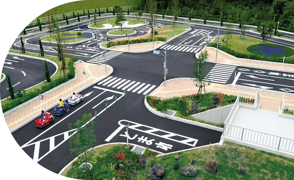 本物そっくりの道路標識や交差点があるコースを、乗り物で走るこども交通公園の全景。