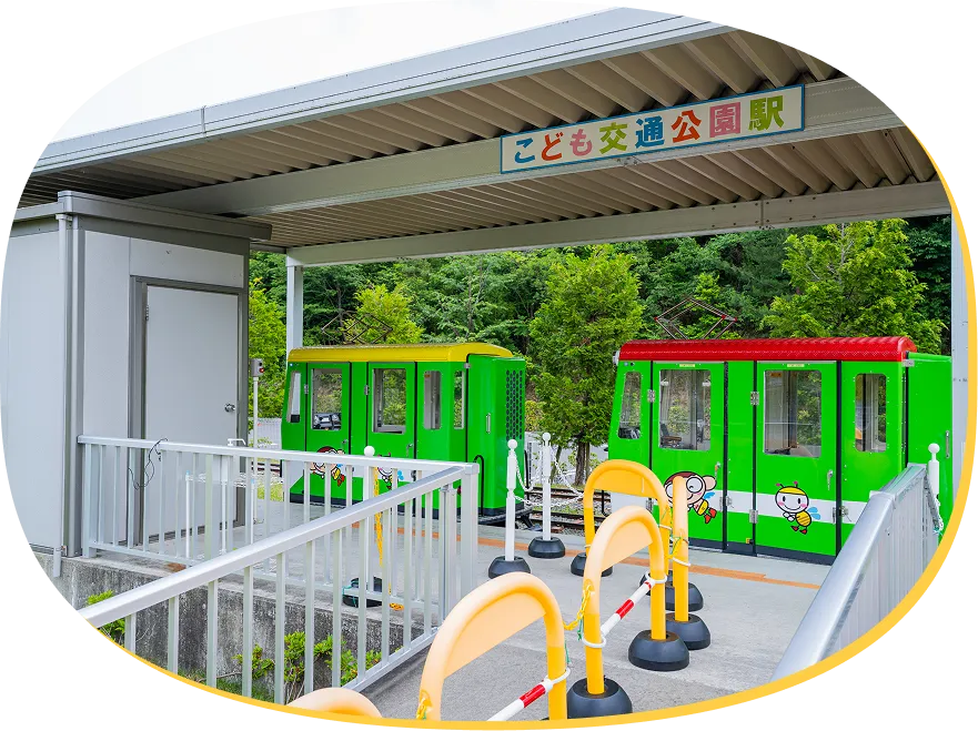 「こども交通公園駅」看板があるプラットホームと停車中のキッズトレイン。