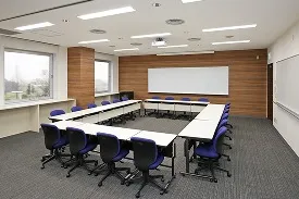 長机と紫の椅子をコの字型に配置した、会議や討論に適した研修室のレイアウト例。