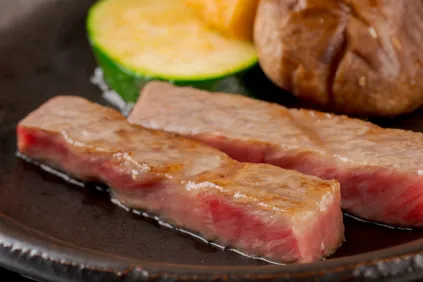 鉄板で香ばしく焼き上げられた分厚いステーキ肉とグリル野菜