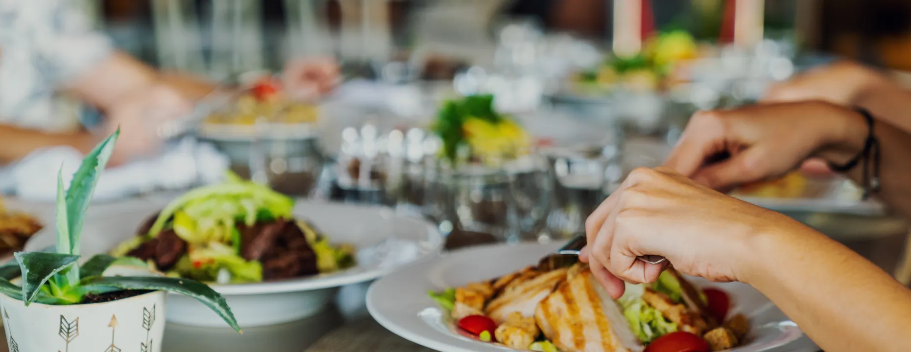 レストランで賑やかに食事を楽しむ様子。