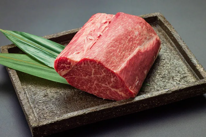 黒い石のプレートの上に飾られた鮮やかな生の高級和牛ブロック肉