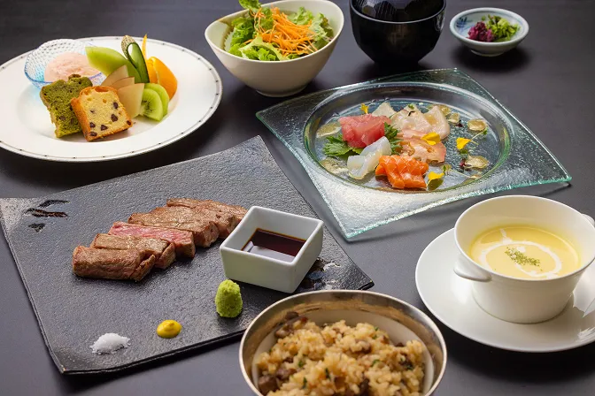 ステーキや前菜、サラダ、ガーリックライスなどが美しく並ぶ華やかなランチコース