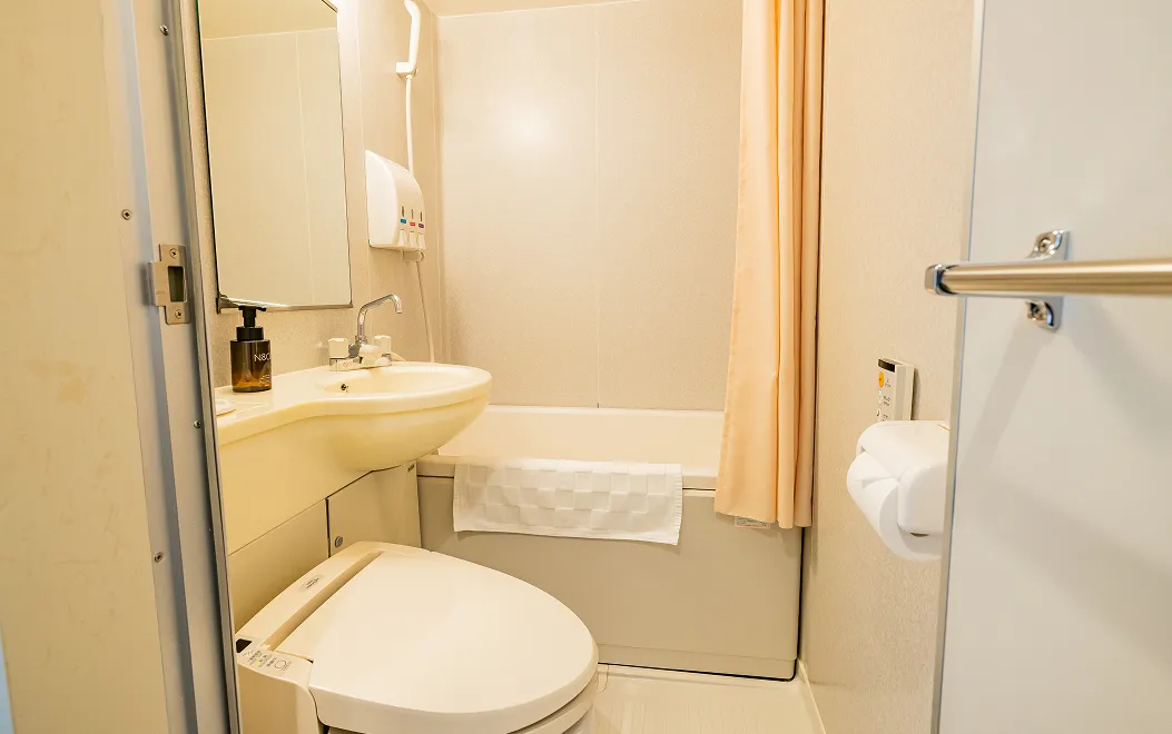 温水洗浄便座付きトイレと洗面台、奥にバスルームがあるユニットバス