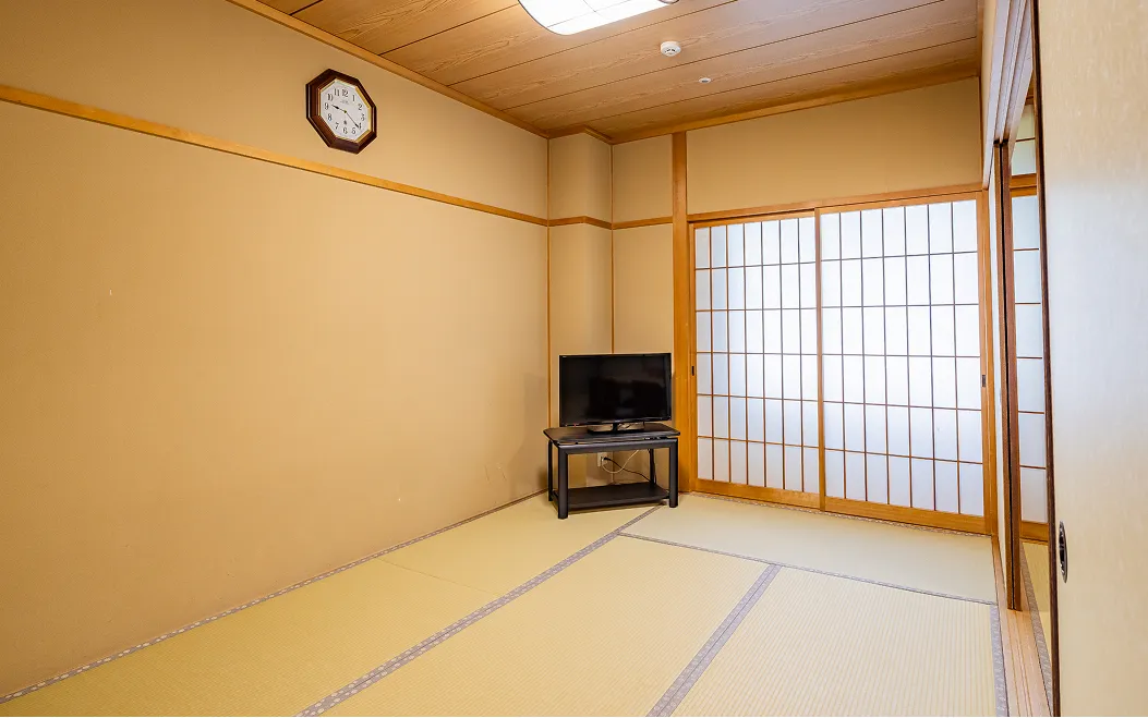 テレビが設置された、シンプルで清潔感のある畳敷きの和室