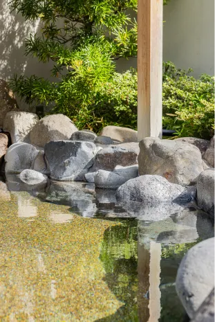 大きな岩場で囲まれた、透き通った湯の露天風呂。